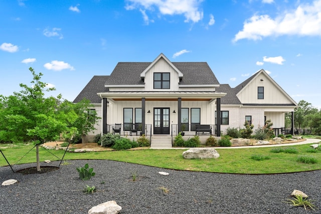 modern farmhouse with a shingled roof, covered porch, board and batten siding, a standing seam roof, and a front lawn