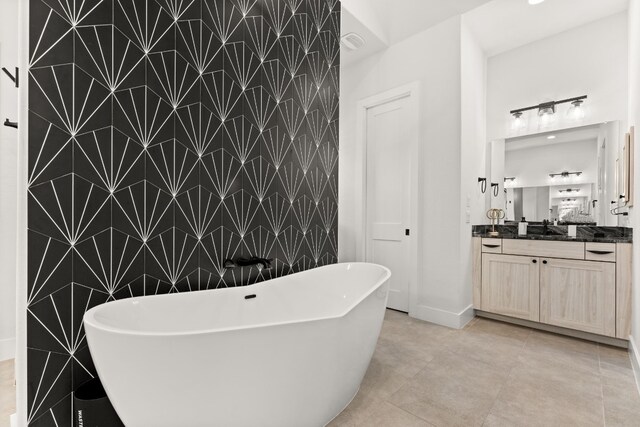 bathroom featuring tile patterned floors, tile walls, a freestanding bath, and vanity