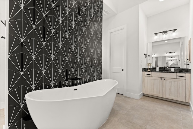 305 Spicewood Trails Dr, Spicewood, TX 78669 - bathroom featuring vanity, a soaking tub, an accent wall, baseboards, and tile patterned flooring