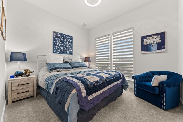 carpeted bedroom featuring visible vents