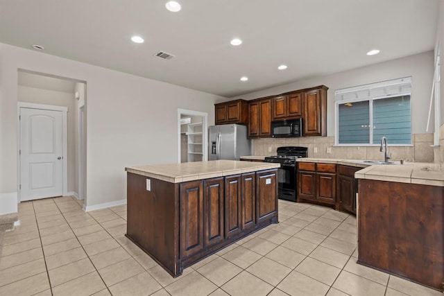 kitchen featuring black appliances, sink, decorative backsplash, a kitchen island, and dark brown cabinetry