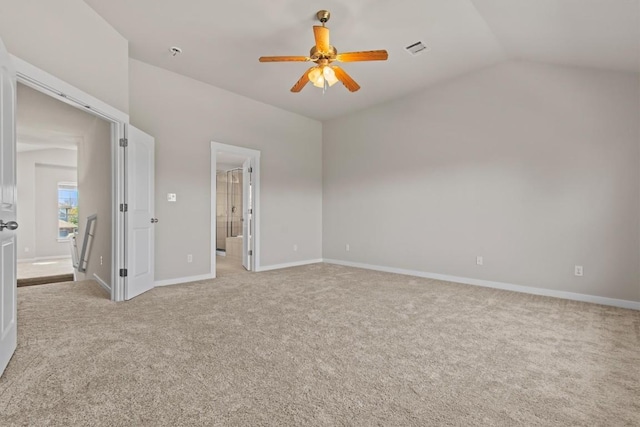 unfurnished bedroom with ceiling fan, light carpet, connected bathroom, and vaulted ceiling