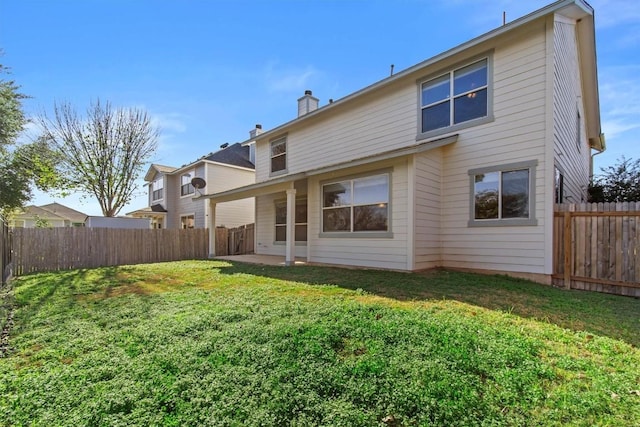 back of house with a lawn and a patio area