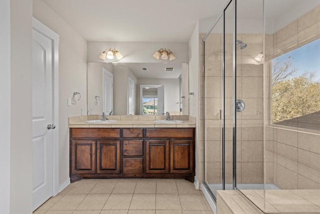 bathroom featuring tile patterned floors, vanity, and a shower with shower door