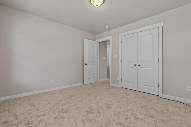 unfurnished bedroom with light carpet and a closet