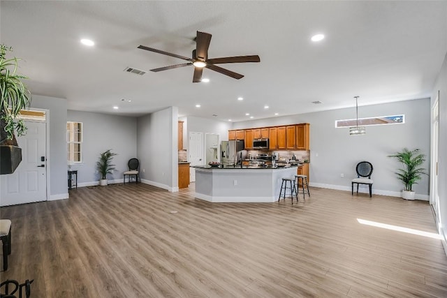 living room with ceiling fan and light hardwood / wood-style floors