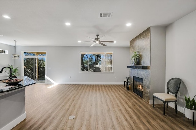 219 Red Poppy Trl, Georgetown, TX 78633 - living room with baseboards, recessed lighting, a tiled fireplace, wood finished floors, and ceiling fan