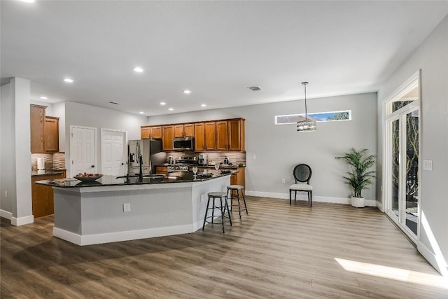 219 Red Poppy Trl, Georgetown, TX 78633 - kitchen with stainless steel appliances, dark countertops, tasteful backsplash, a sink, and recessed lighting