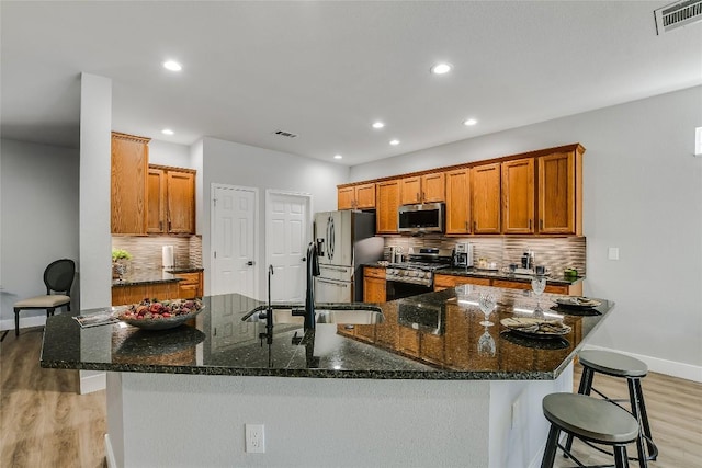219 Red Poppy Trl, Georgetown, TX 78633 - kitchen with stainless steel appliances, a sink, baseboards, a breakfast bar area, and recessed lighting