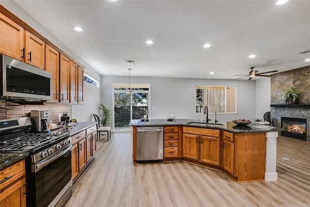 219 Red Poppy Trl, Georgetown, TX 78633 - kitchen featuring stainless steel appliances, a sink, light wood-style floors, brown cabinets, and recessed lighting