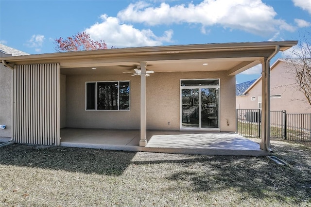 rear view of property with ceiling fan and a patio area