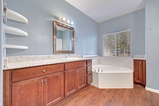 bathroom with a washtub and vanity