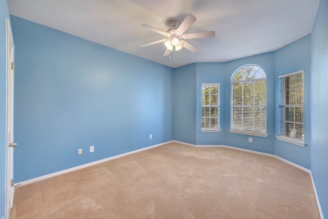 empty room featuring light colored carpet and ceiling fan