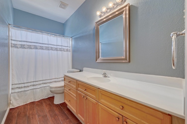 bathroom with hardwood / wood-style floors, vanity, a shower with shower curtain, and toilet