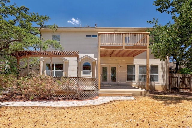 rear view of house featuring a pergola, french doors, a balcony, and a yard