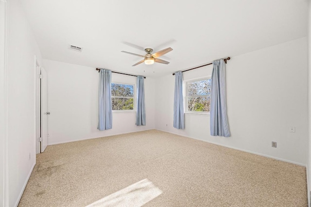 carpeted spare room with ceiling fan and a healthy amount of sunlight