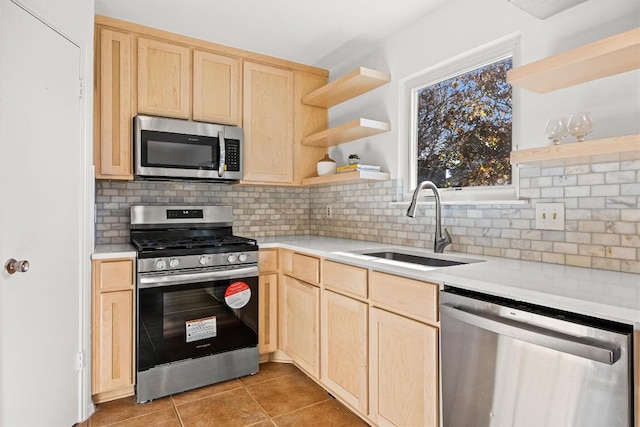 kitchen with backsplash, sink, light tile patterned floors, light brown cabinetry, and appliances with stainless steel finishes