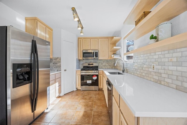 kitchen featuring light brown cabinetry, backsplash, a wealth of natural light, stainless steel appliances, and sink