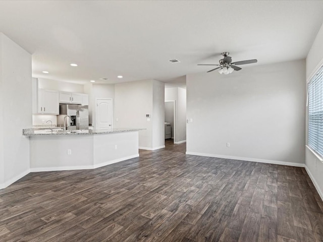 unfurnished living room featuring ceiling fan and dark hardwood / wood-style flooring