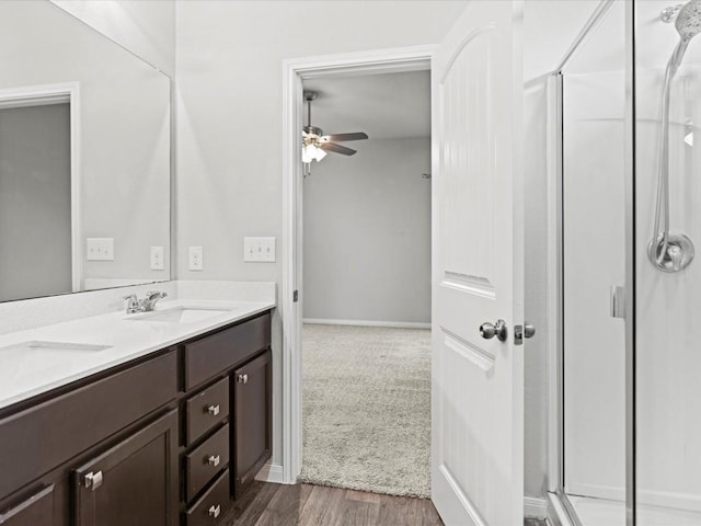 bathroom featuring hardwood / wood-style floors, vanity, a shower with door, and ceiling fan