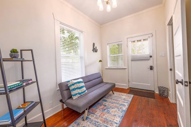 sitting room with a healthy amount of sunlight, ornamental molding, dark wood-type flooring, and a notable chandelier