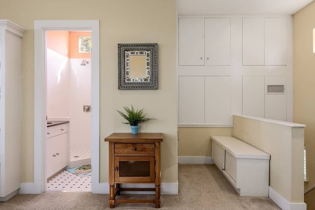 hallway featuring light colored carpet