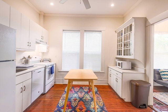 kitchen featuring crown molding, dark hardwood / wood-style flooring, white appliances, and white cabinetry