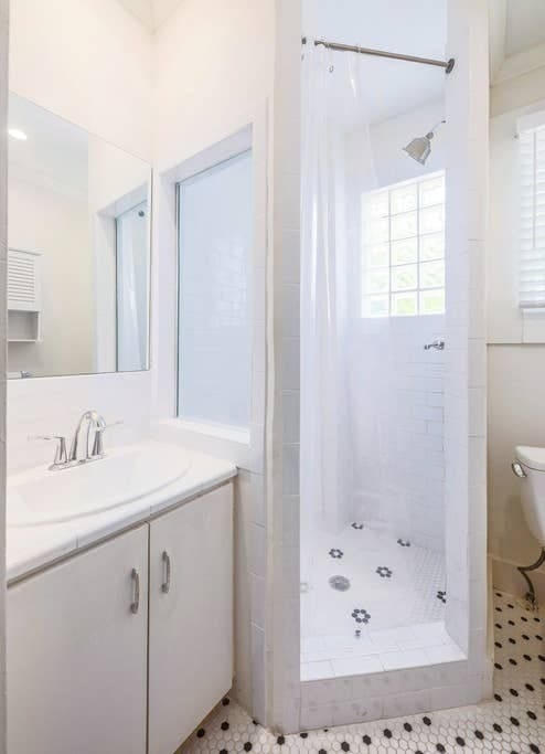 bathroom with toilet, vanity, tile patterned flooring, and a shower with shower curtain