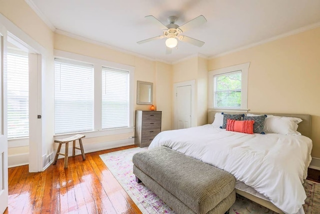 bedroom featuring ceiling fan, ornamental molding, and light hardwood / wood-style flooring