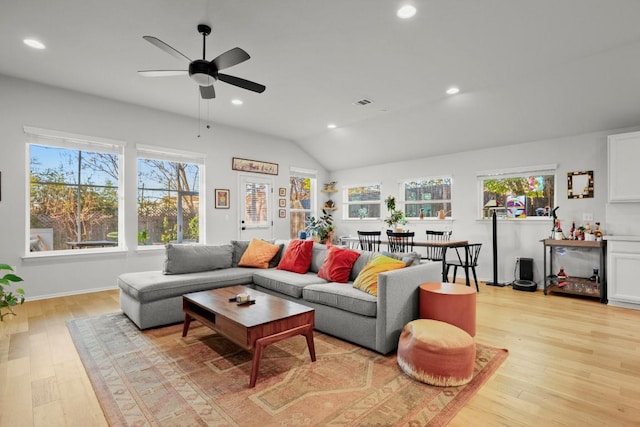 living room featuring ceiling fan, vaulted ceiling, and light hardwood / wood-style flooring