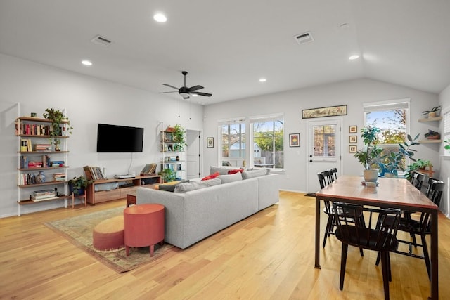 living room featuring ceiling fan, light hardwood / wood-style flooring, and vaulted ceiling