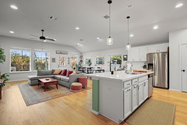 kitchen featuring ceiling fan, sink, an island with sink, white cabinets, and appliances with stainless steel finishes