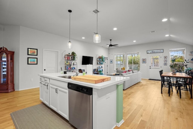 kitchen with stainless steel dishwasher, sink, pendant lighting, white cabinets, and an island with sink