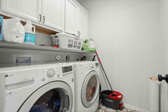 laundry room featuring washing machine and clothes dryer and cabinets