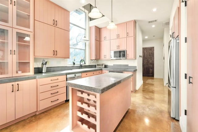 kitchen featuring stainless steel appliances, sink, light brown cabinets, pendant lighting, and a center island