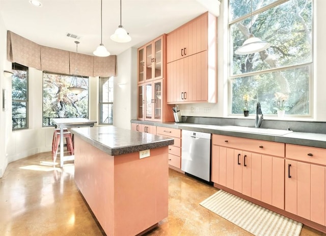 kitchen featuring stainless steel dishwasher, a wealth of natural light, light brown cabinets, decorative light fixtures, and a kitchen island