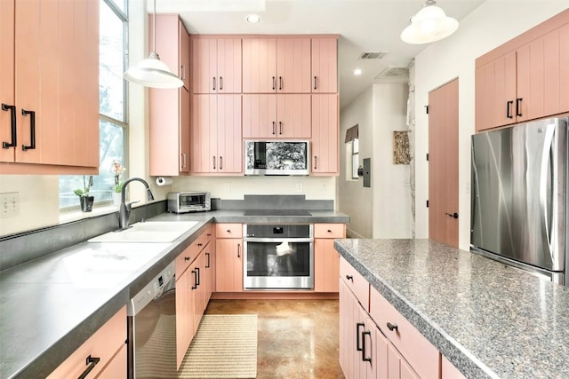 kitchen with pendant lighting, light brown cabinets, stainless steel appliances, and sink