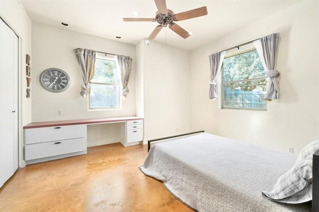 bedroom with ceiling fan, built in desk, and baseboard heating