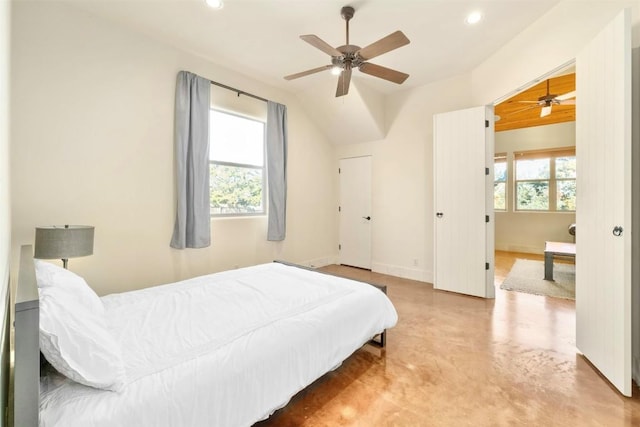 bedroom with multiple windows, concrete flooring, and ceiling fan