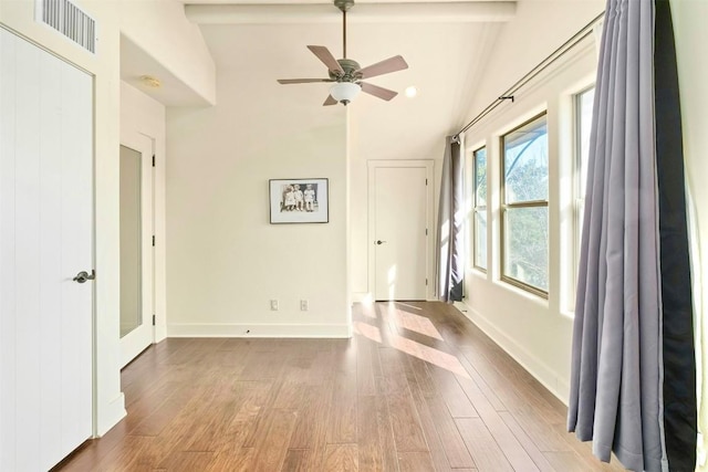 empty room with lofted ceiling with beams, ceiling fan, and light hardwood / wood-style flooring