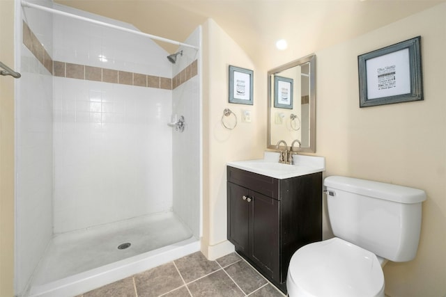 bathroom featuring tiled shower, vanity, toilet, and tile patterned flooring