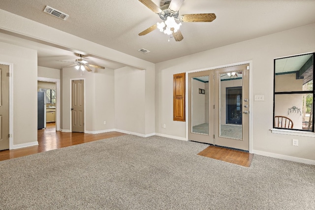 carpeted spare room featuring ceiling fan and a textured ceiling