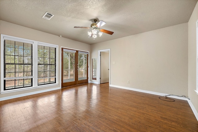 unfurnished room with hardwood / wood-style floors, ceiling fan, a textured ceiling, and french doors