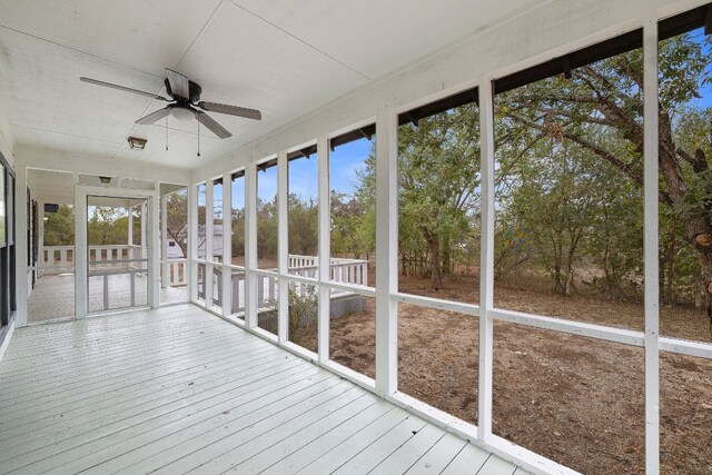 unfurnished sunroom featuring ceiling fan