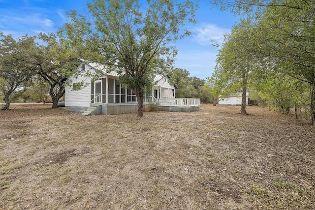 view of yard with a sunroom and a wooden deck