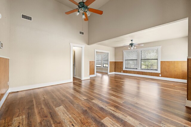 unfurnished living room featuring ceiling fan, dark hardwood / wood-style flooring, and high vaulted ceiling