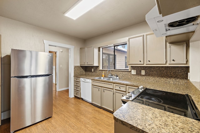 kitchen with sink, range with electric stovetop, stainless steel fridge, white dishwasher, and decorative backsplash