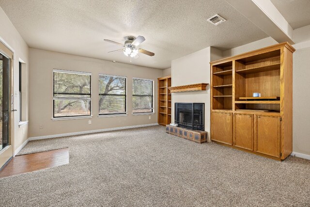 unfurnished living room with ceiling fan, light colored carpet, and a textured ceiling