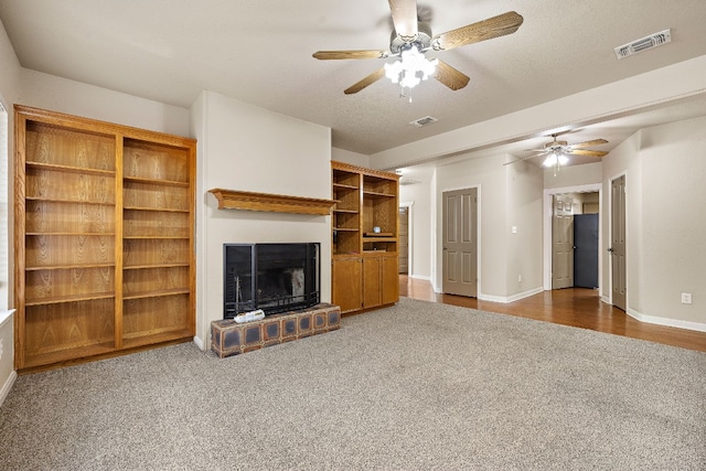 3480 Jack C Hays Trl, Buda, TX 78610 - unfurnished living room featuring visible vents, baseboards, a fireplace with raised hearth, and a ceiling fan