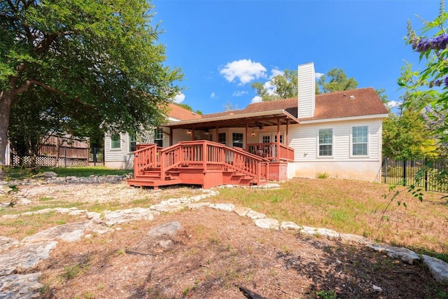 rear view of property featuring ceiling fan and a deck